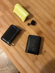 Click to view full screen Disassembled yellow and black Geek Bar device with outer shell and mouthpiece on a table