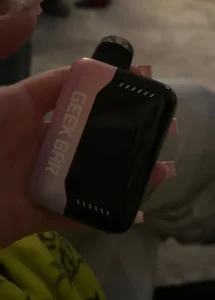 Click to view full screen Pink and black Geek Bar device held in a hand